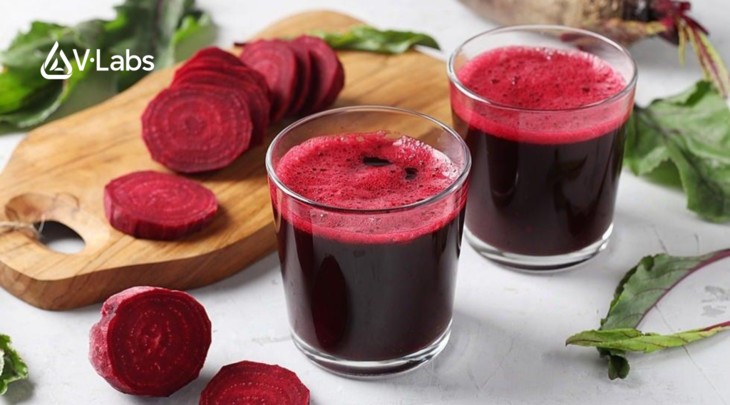 a glass of red juice next to sliced beets